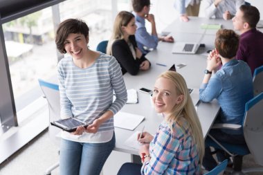 Güzel iş kadınları kullanarak Tablet içinde ofis binası konferans sırasında