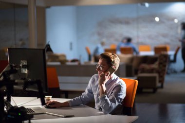 karanlık ofisinde cep telefonu kullanan adam