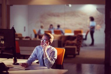 karanlık ofisinde cep telefonu kullanan adam