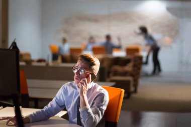 karanlık ofisinde cep telefonu kullanan adam