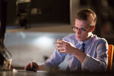 karanlık ofisinde cep telefonu kullanan adam