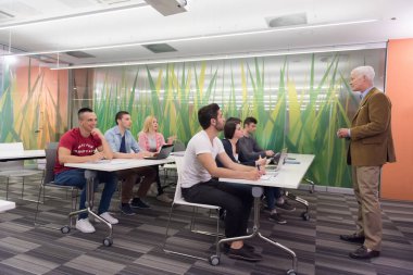 bir grup öğrenci sınıfta öğretmenle