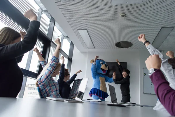 stock image boss dressed as bear having fun with business people in trendy office