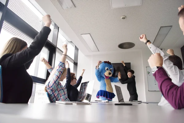 stock image boss dressed as bear having fun with business people in trendy office