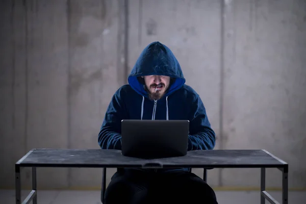 年轻的黑客使用笔记本电脑 而在黑暗的办公室工作 — 图库照片