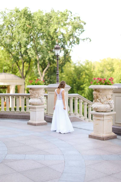 Stock image Young bride walking outside in white dress.