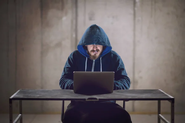stock image young hacker using laptop computer while working in dark office