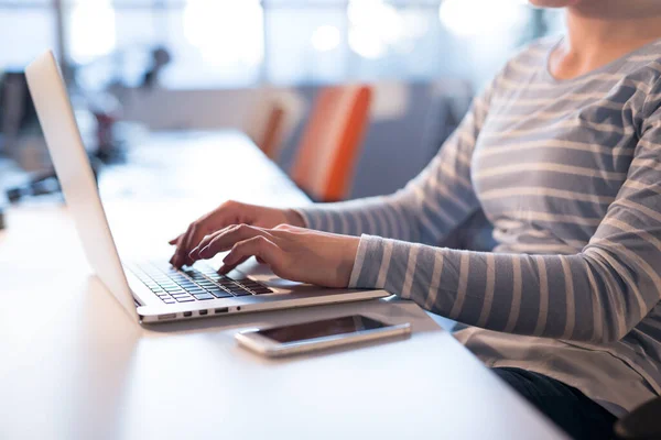 başlangıç ofisinde bir dizüstü bilgisayar kullanarak iş kadını