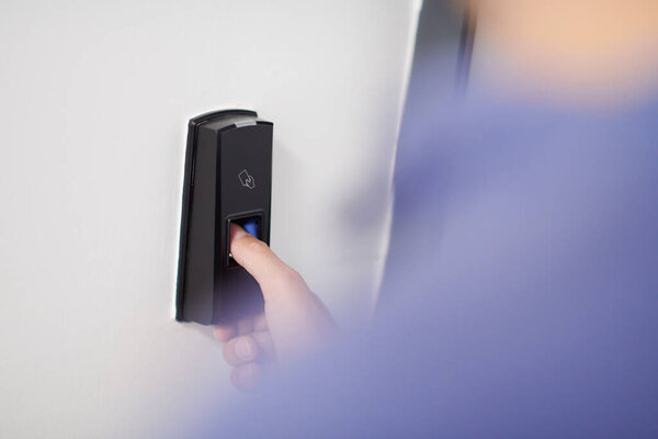 человек нажимает сканер отпечатков пальцев