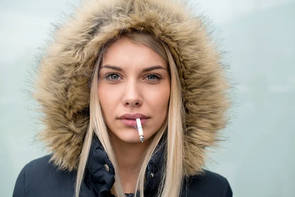 口の中にタバコを持つ若いブロンドの女の子の肖像画 — ストック写真