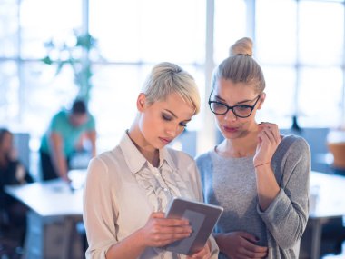 Güzel iş kadınları kullanarak Tablet içinde ofis binası konferans sırasında