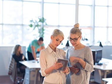 Güzel iş kadınları kullanarak Tablet içinde ofis binası konferans sırasında
