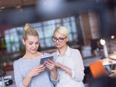 Güzel iş kadınları kullanarak Tablet içinde ofis binası konferans sırasında