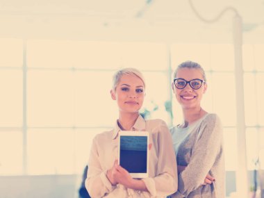 Güzel iş kadınları kullanarak Tablet içinde ofis binası konferans sırasında