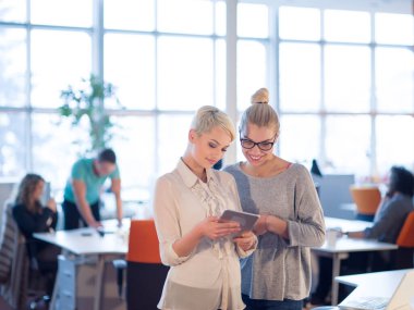 Güzel iş kadınları kullanarak Tablet içinde ofis binası konferans sırasında