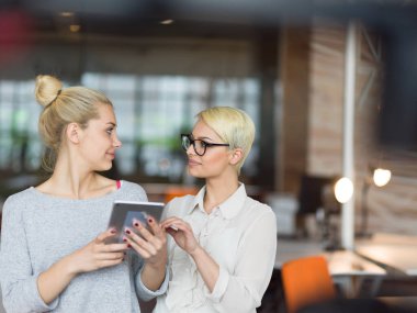 Güzel iş kadınları kullanarak Tablet içinde ofis binası konferans sırasında