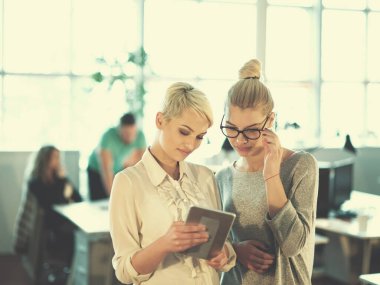 Güzel iş kadınları kullanarak Tablet içinde ofis binası konferans sırasında