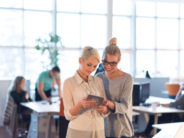 Güzel iş kadınları kullanarak Tablet içinde ofis binası konferans sırasında