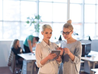 Güzel iş kadınları kullanarak Tablet içinde ofis binası konferans sırasında
