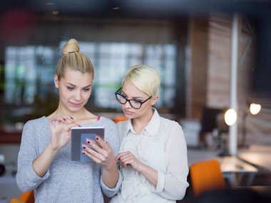 Güzel iş kadınları kullanarak Tablet içinde ofis binası konferans sırasında