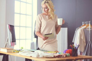 Stüdyoda tasarımcı kadın tasarımları üzerinde çalışıyor.