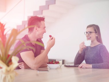 Çiftler sabah kahvesi ve çilek yiyor.