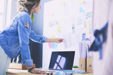 Stüdyoda tasarımcı kadın tasarımları üzerinde çalışıyor.