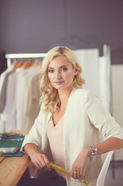 Stüdyoda tasarımcı kadın tasarımları üzerinde çalışıyor.