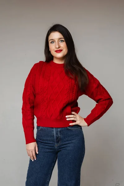 赤いセーターと青いジーンズを着た陽気な女性 — ストック写真