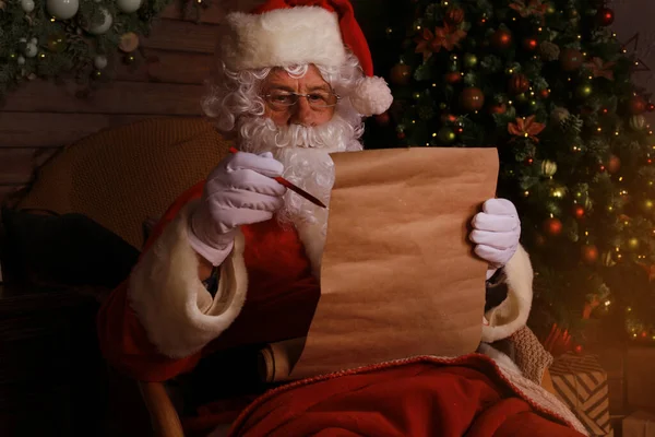 Портрет Счастливого Санта Клауса Сидящего Себя Дома Возле Елки Читающего — стоковое фото