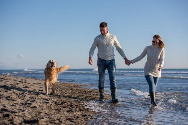 Köpekli çift sonbahar günü sahilde eğleniyor.