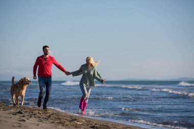 Köpekli çift sonbahar günü sahilde eğleniyor.