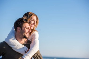 Çiftler sonbaharda kumsalda eğleniyorlar.