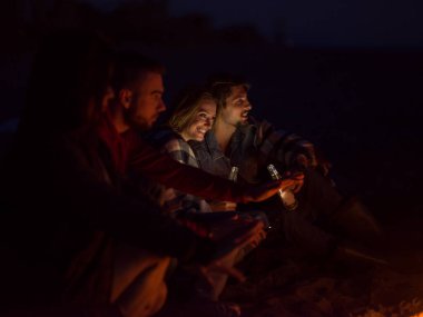 Çift gece arkadaşlarıyla sahilde eğleniyor.