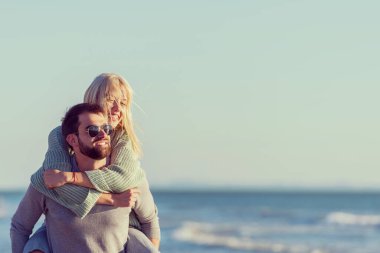 Çiftler sonbaharda kumsalda eğleniyorlar.