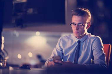 karanlık ofisinde cep telefonu kullanan adam