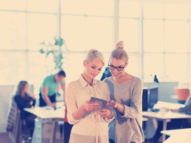 Güzel iş kadınları kullanarak Tablet içinde ofis binası konferans sırasında