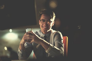 karanlık ofisinde cep telefonu kullanan adam