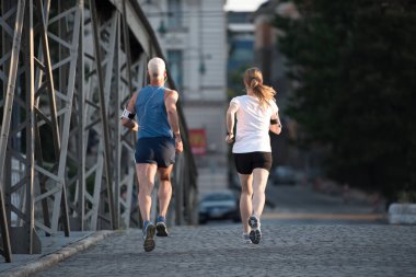 Şehirde koşan bir çift.