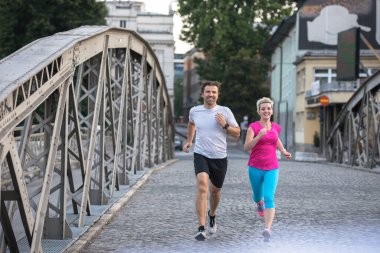 Şehirde koşan bir çift.