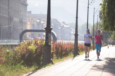 İki bayan arkadaş koşuyor.