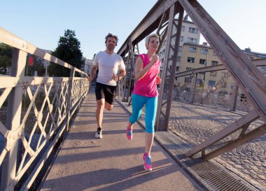 Şehirde koşan bir çift.