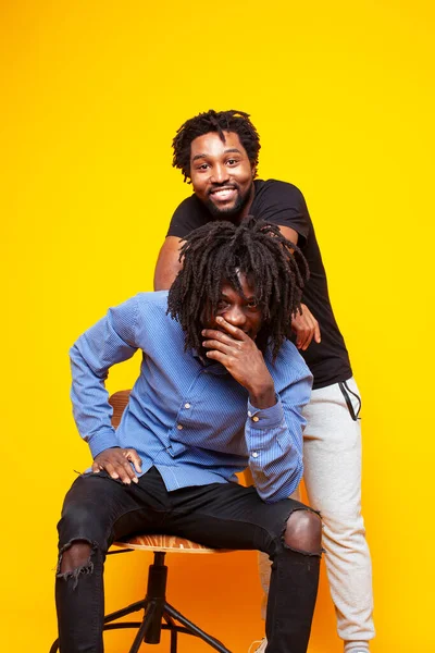 2人のアフリカ系アメリカ人が黄色を背景に一緒に陽気にポーズをとり — ストック写真
