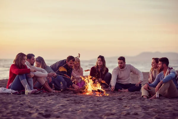 Grupo Jóvenes Amigos Sentados Junto Fuego Playa —  Fotos de Stock
