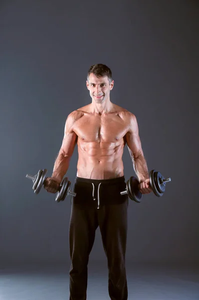ハンサムな筋肉男がダンベルでワークアウトします 個人的なフィットネスのインストラクター パーソナル トレーニング — ストック写真