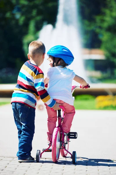 男孩和女孩在公园里学骑自行车 — 图库照片