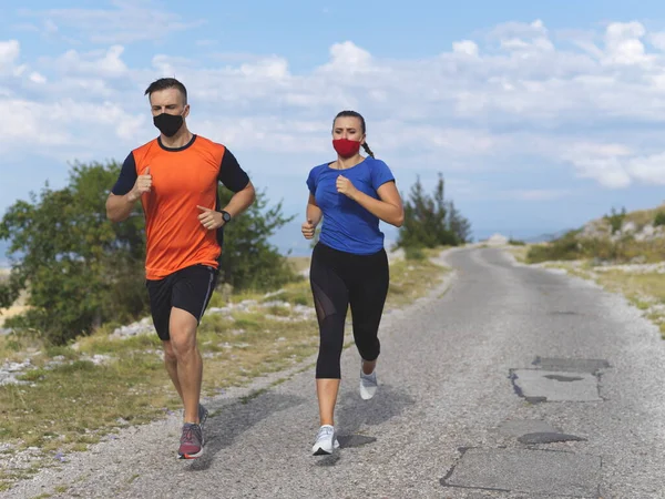couple running in nature wearing masks
