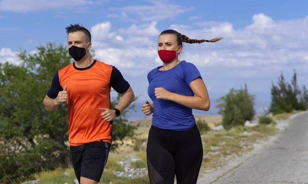 夫妻二人带着面具在大自然中奔跑 — 图库照片