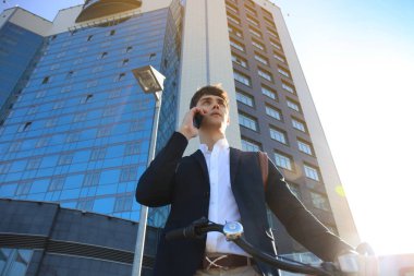Bisiklet ve şehir sokak smartphone ile genç işadamı