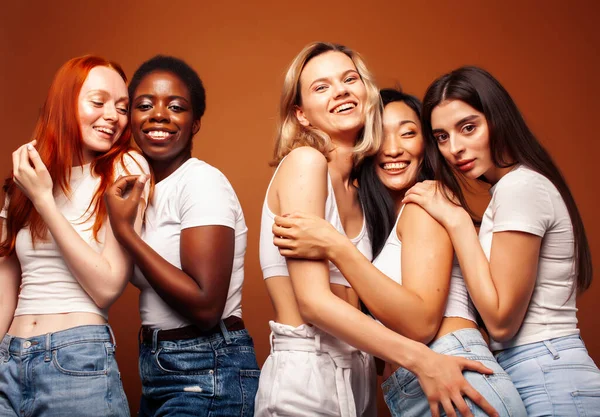 若いアフリカ人女性と白人女性がブラウンを背景に陽気で多様な国籍の人々のコンセプト — ストック写真